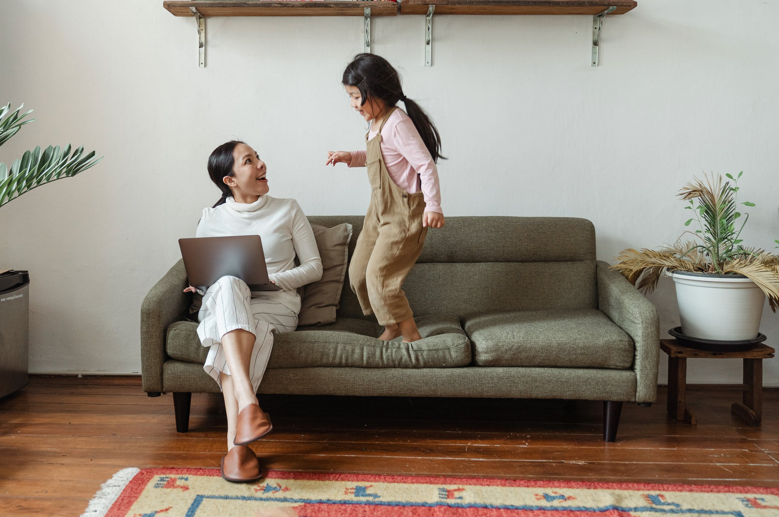 girl jumping on couch with mom