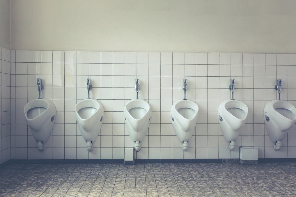 white urinals lined up in bathroom