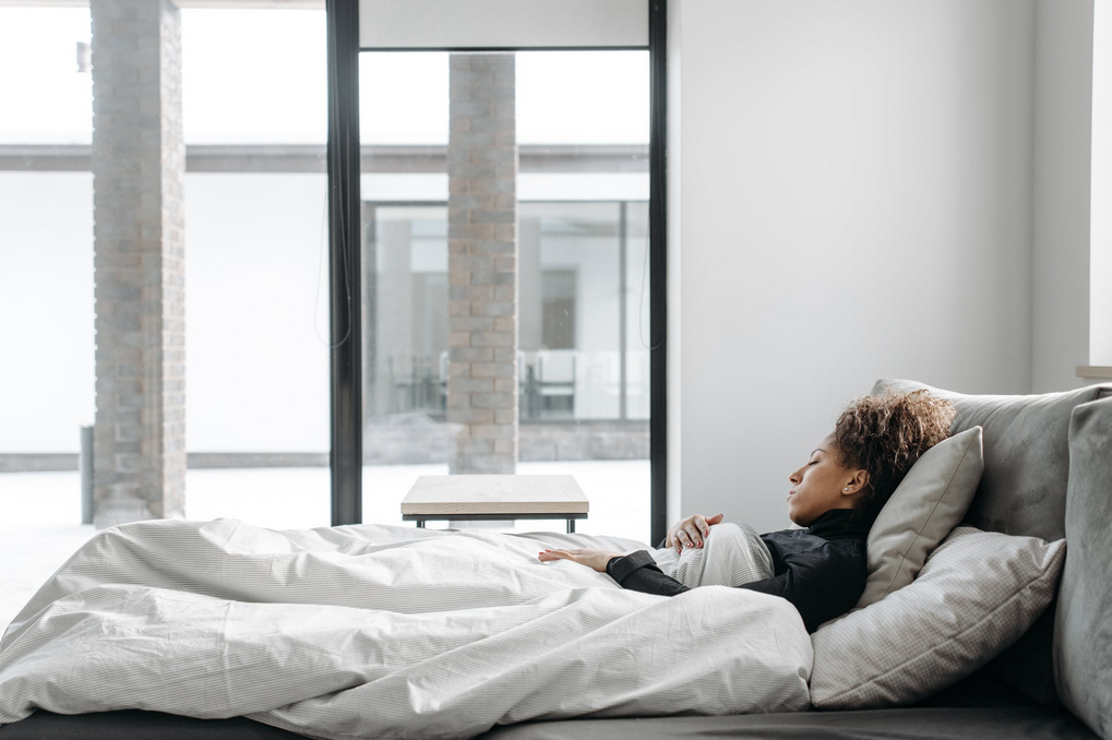 woman sleeping on gray sofa bed