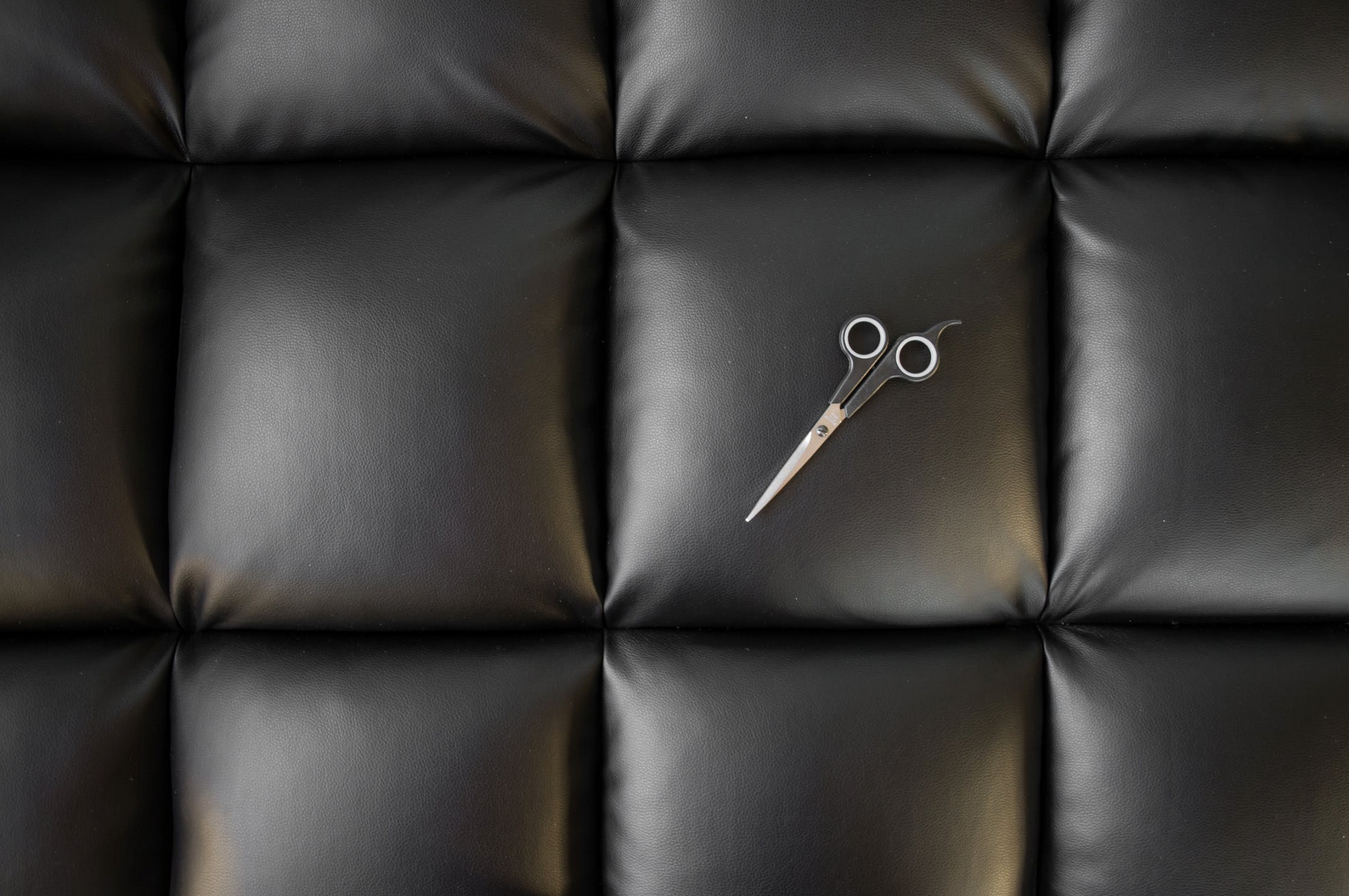 black leather sofa with scissors on it