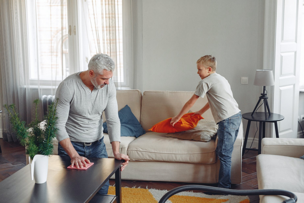 father and son cleaning a couch